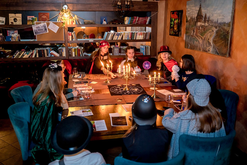 Дети разгадывают загадки в семейном квесте Хэллоуина в Minsk